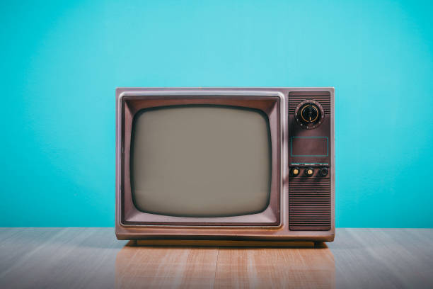 istock Retro old tv on wooden table with blue concrete wall background. 1370889764