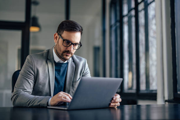 istock Serious caucasian man, making sure his staff is working hard, on laptop. 1370889880