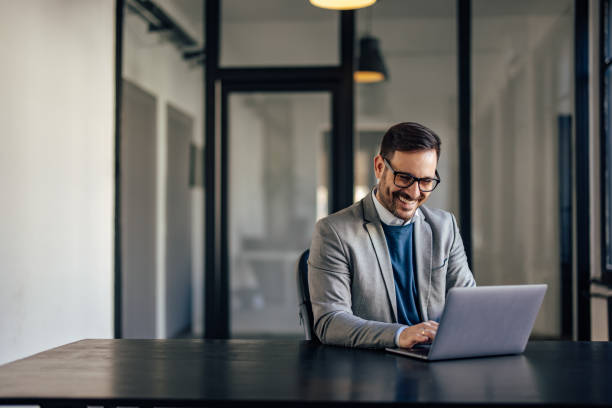 istock Smiling caucasian man with glasses, contacting his clients online. 1370889885