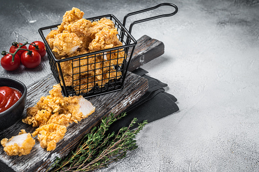 Dip Fried chicken popcorn with ketchup in a basket. White background. Top view. Copy space.