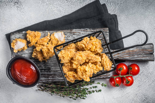 istock Dip Fried chicken popcorn with ketchup in a basket. White background. Top view 1370891238