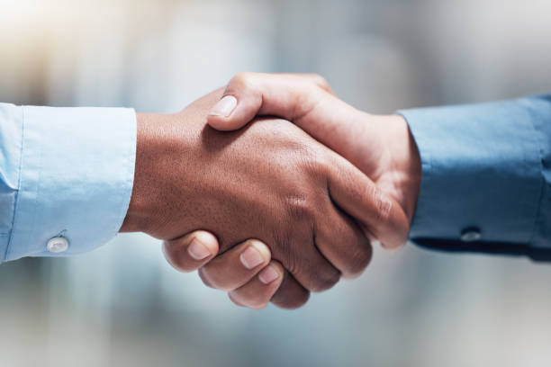 istock Shot of two unrecognizable businesspeople shaking hands in an office at work 1370892082