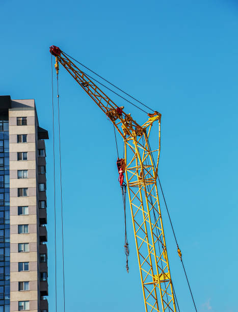 istock High-rise construction crane with a long yellow boom against the blue sky 1370892510