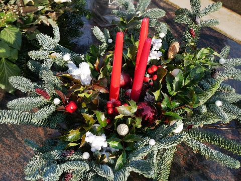 Christmas candle arrangement with pine and ribbons on red.