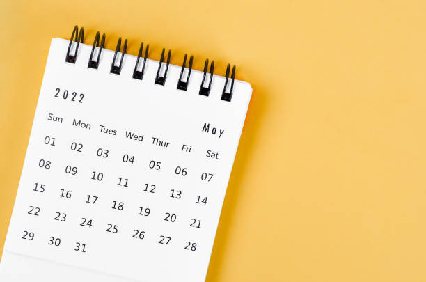 istock May 2022 desk calendar on light yellow background. 1370895011