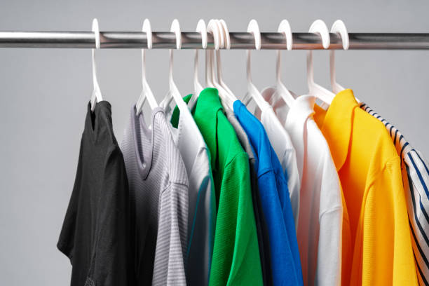 istock Clothes hang on clothing rack over white background. 1370895892
