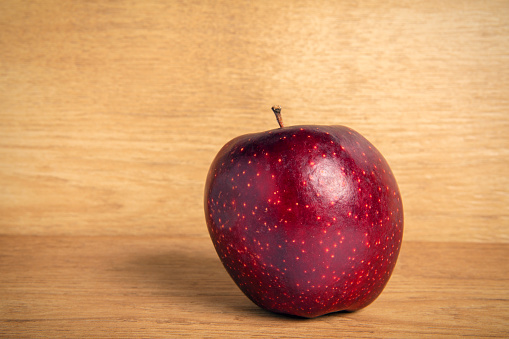 An apple isolated on a wood background with lots of copy space.