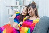 lgbt-konzept-zwei-junge-frauen-in-einem-regenbogenkleid-benutzen-ein-tablet-auf-dem-sofa-im.jpg?b=1&s=170x170&k=20&c=lNAkmMkrE9khOh4AElJYqV2ZD8K6fjE8qUJ6Cy1-wtA=