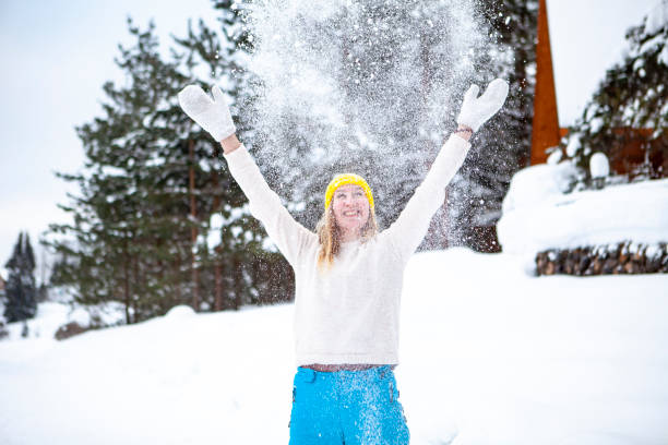 istock Woman cheerfully throws snow 1370902610