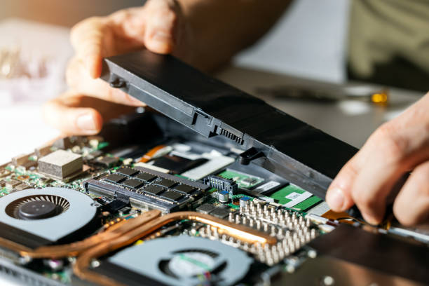 technician change and insert new laptop battery. computer repair service stock photo