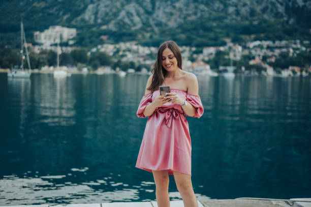 istock Woman using smartphone while walking on the city streets on the coast 1370904145