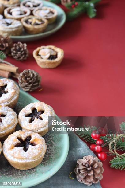 Image Homemade Mince Pies Festive Christmas Dessert Crispy Pastry Filled With Sweet Mincemeat Topped With Star Shaped Pastry Pine Cones Spruce And Red Berries Red Background Focus On Foreground Copy Space Stock Photo - Download Image Now