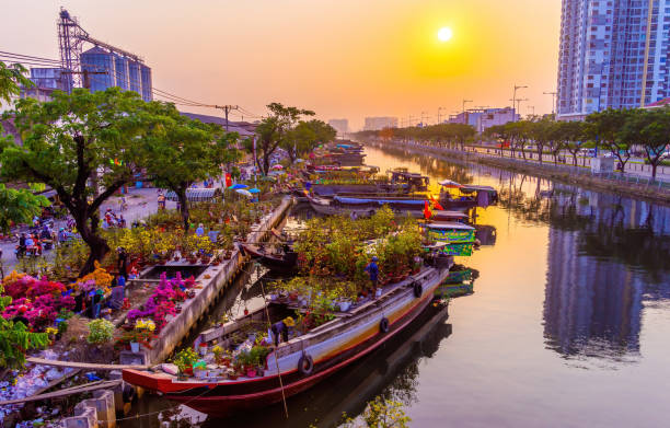 Springtime in Saigon, boat on canal, transport spring flower for Tet to Ben Binh Dong open air market, Vietnamese happy with Lunar New Year, Vietnam