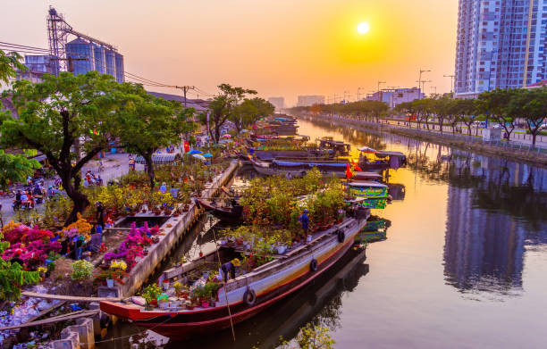 Springtime in Saigon, boat on canal, transport spring flower for Tet to Ben Binh Dong open air market, Vietnamese happy with Lunar New Year, Vietnam stock photo