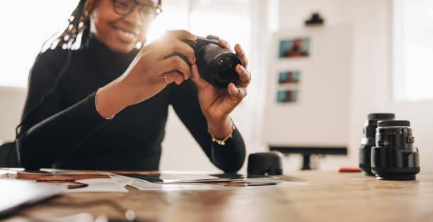 istock Woman holding a dslr camera in her home office 1370906688