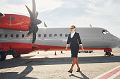 blick-weit-weg-junge-stewardess-die-in-formeller-schwarzer-kleidung-ist-steht-im-freien-in-der.jpg?b=1&s=170x170&k=20&c=lv5T30lL4J3UnwvqWsnMUPG_DjPLwhCEdj6ZkldnO7g=