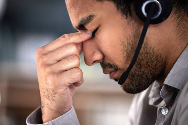 istock Shot of a handsome young customer service agent feeling stressed in the office 1370907804