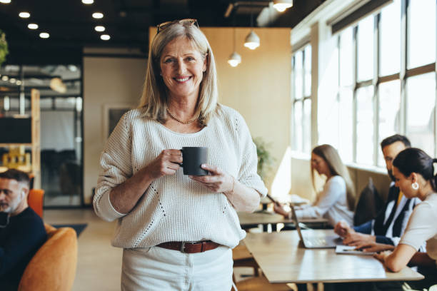 istock Smiling mature businesswoman standing in a co-working space 1370908242