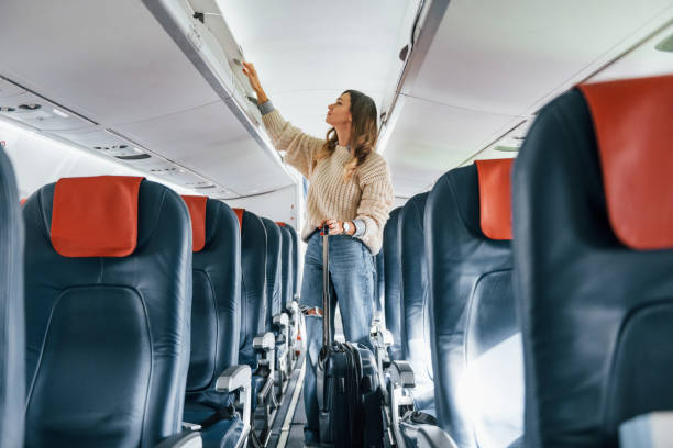 istock Front view. Young female passanger in casual clothes is in the plane 1370908488
