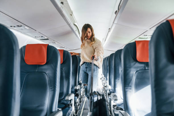 istock Front view. Young female passanger in casual clothes is in the plane 1370908515