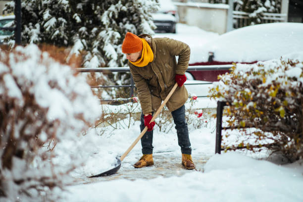 Man clearing snow in a yard Man shoveling snow during heavy winter weather Shoveling Snow stock pictures, royalty-free photos & images