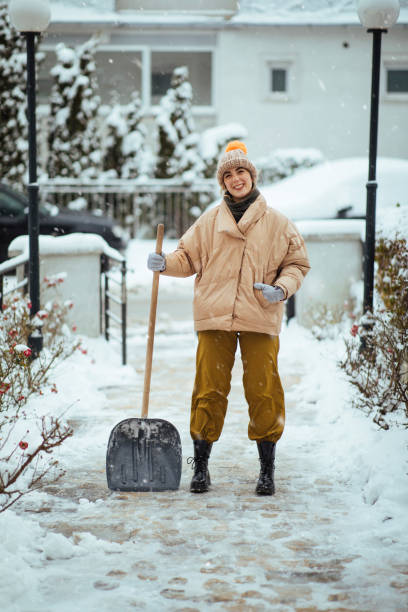 istock Happy woman clearing path from snow 1370910666