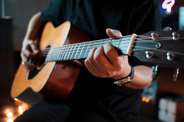 istock man's hands playing acoustic guitar. 1370911207