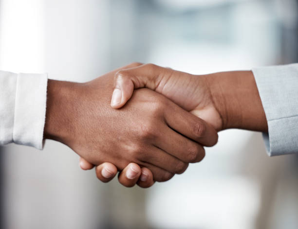 istock Shot of two unrecognizable businespeople shaking hands in an office at work 1370911571