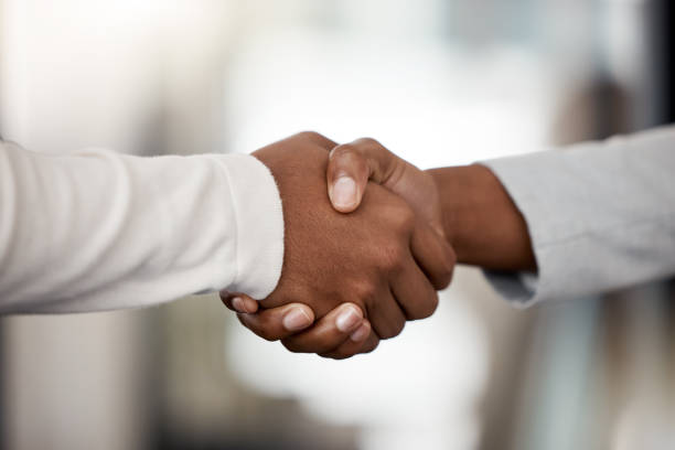 istock Shot of two unrecognizable businespeople shaking hands in an office at work 1370911588