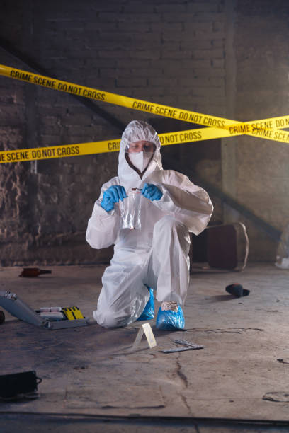 istock Criminologist in protective suit puts a  bullet casings in plastic bag as physical evidences at the crime scene 1370912936
