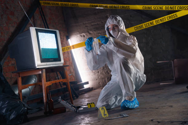 istock Criminologist in protective suit with bullet casings in plastic bag as physical evidences at the crime scene 1370912949