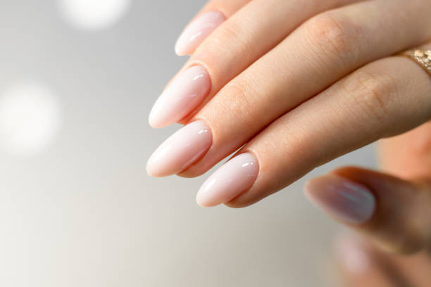 Beautiful nude manicure. Mandala nails. Nail design. Manicure with gel polish. Close-up of the hands of a young woman with a gentle nude manicure on the nails. Bright nails with gel polish.