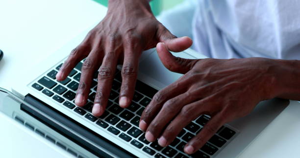 istock Black african descent hands typing on computer laptop from above angle 1370914894