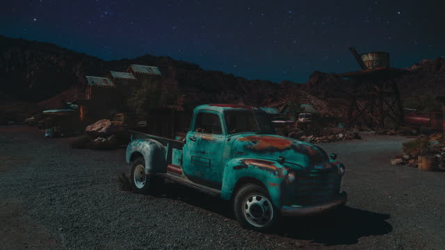 Old rusty Vintage USA pickup truck standing in the desert of Nevada. Retro car in an American Ghost Town. Cinemagraph / seamless video loop time lapse of the stars moving along the sky.