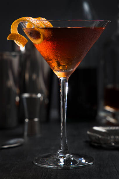 манхэттенский коктейль с оранжевой изюминкой в качестве гарнира - manhattan cocktail стоковые фото и изображения