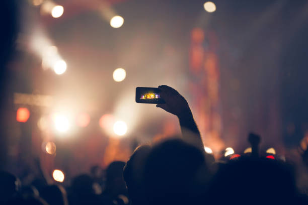 istock Person holding modern smartphone on a concert. 1370925762