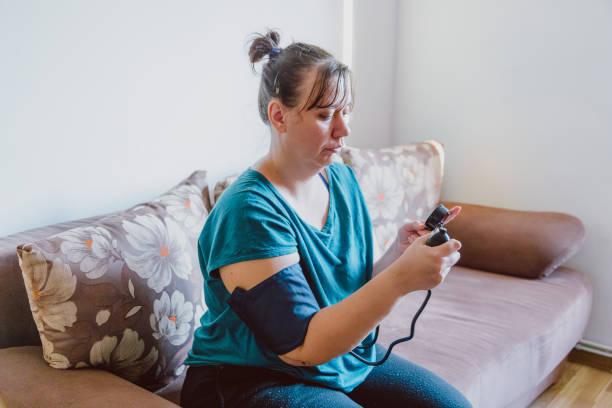 istock Woman checking blood pressure using machine at home 1370925791