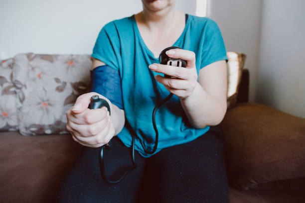 istock Woman checking blood pressure using machine at home 1370925794