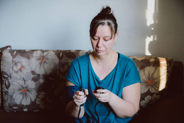 istock Woman checking blood pressure using machine at home 1370925796