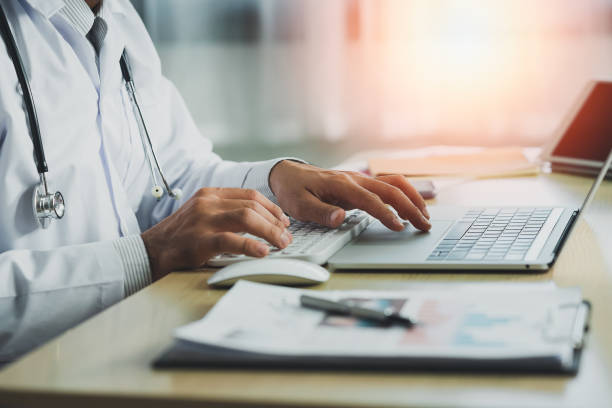 istock Doctor working with chart paper and laptop computer looking graph. Male doctor work at office hospital. Health hospital concept 1370928195