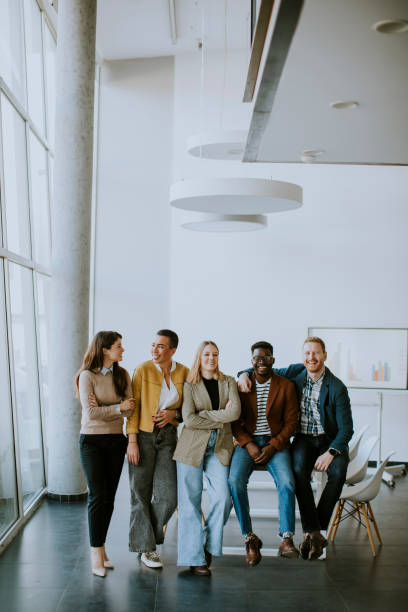 Group of positive businesspeople standing together in the office stock photo