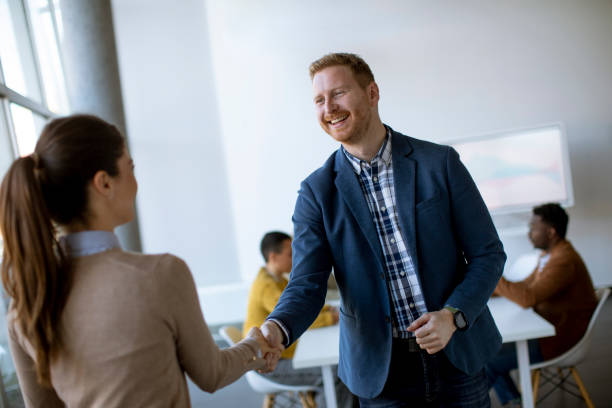 istock Young business partners making handshake in an office 1370929976