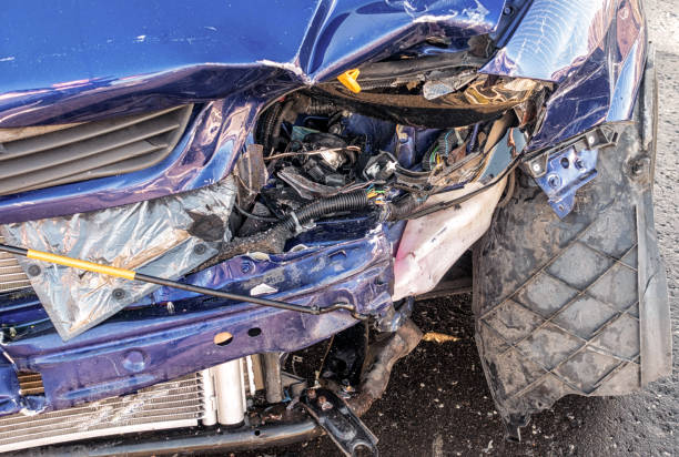 Close-up of the front of a smal car, showing unrepairable damage.