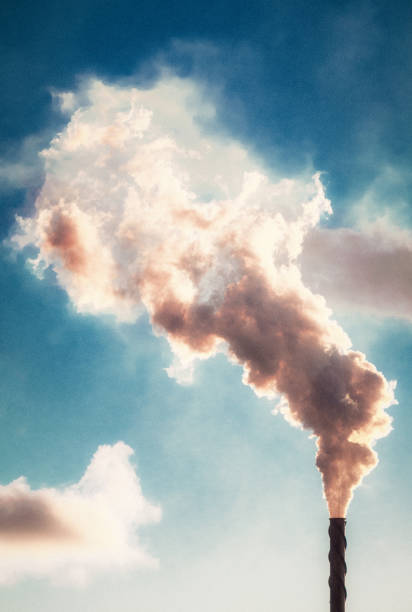 Effluent rising into the sky from an industrial chimney stack.
