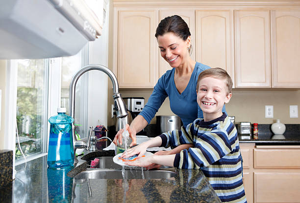 istock Mom and Son washing dishes in kitchen sink. 137093630