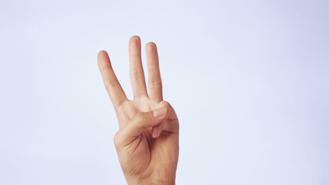 close-up of a man's hand with three fingers raised up isolated on a white background