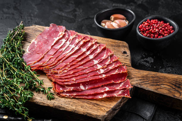 istock Sliced Turkish bacon Pastrami, roasted beef meat. Black background. Top view 1370936962