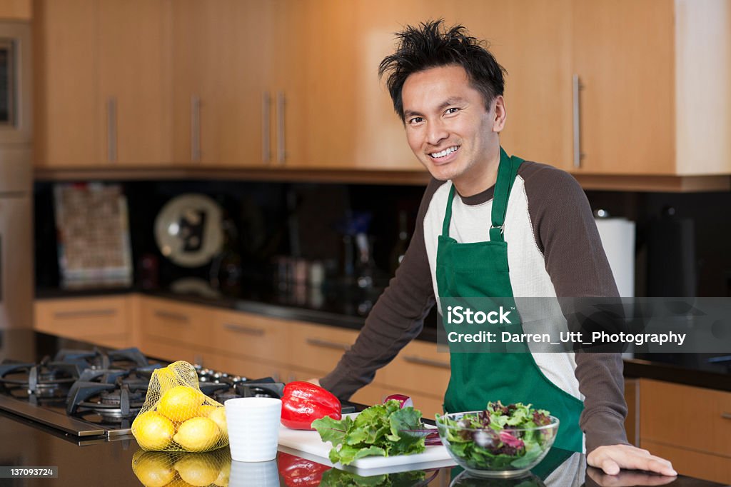 Homem sorridente, usando lotes na cozinha - Foto de stock de Adulto royalty-free