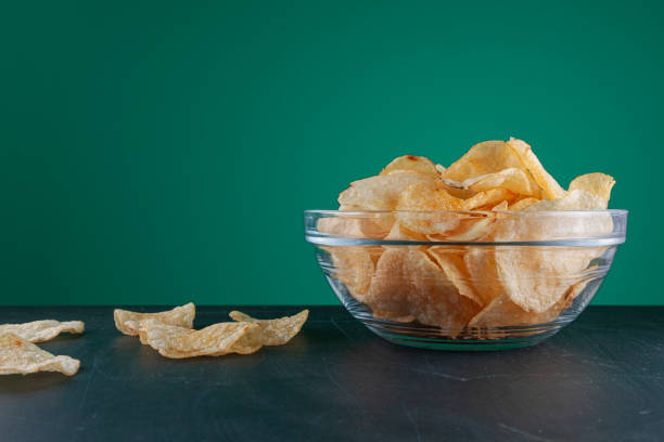 istock A bowl of chips over a green wood scratched table 1370937498
