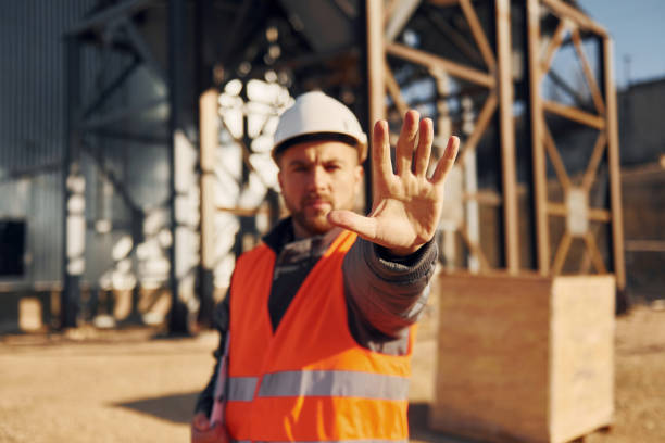 istock Natural lighting. Construction worker in uniform is outdoors near the factory 1370938163